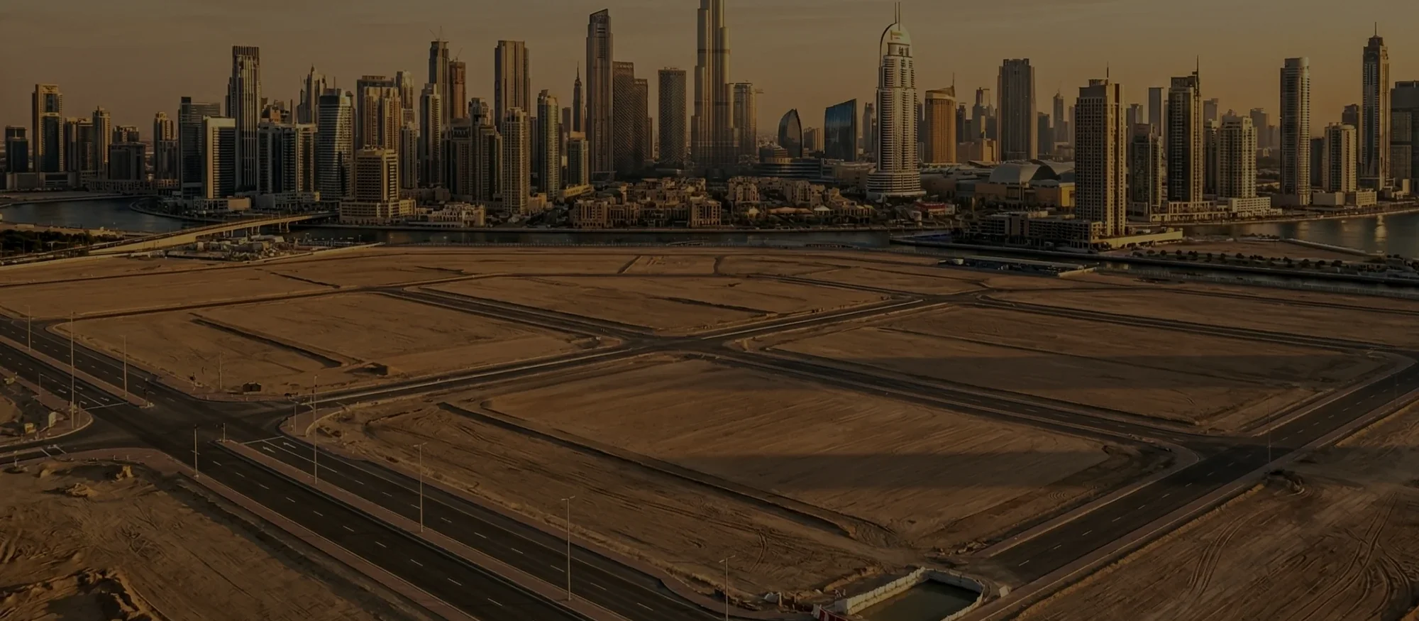 Open plots of land in Dubai with the city skyline behind